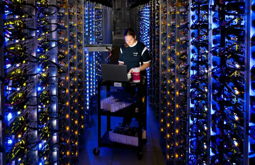 Google engineer working on server racks inside a data center in The Dalles Oregon surrounded by blue LED lit hardware
